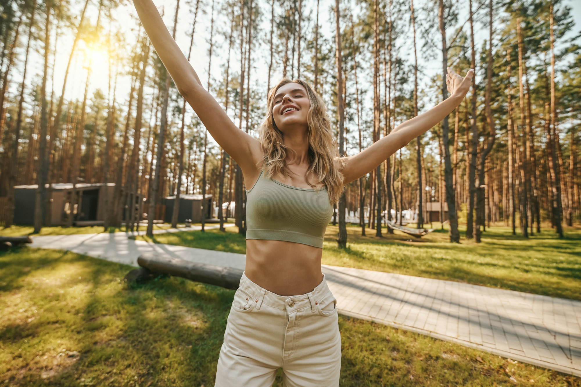 Happy woman with closed eyes and hands raised up